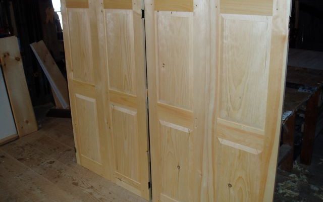 Pair of custom doors for a low height storage area that makes use of the extra unused space under the roof line on an upper story of a house.