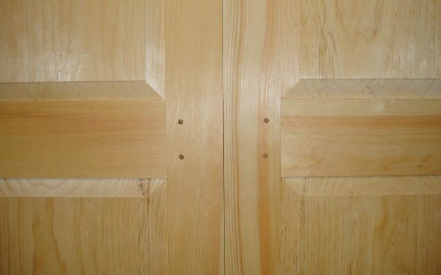 Mid-rail detail on a pair of custom doors for a low height storage area that makes use of the extra unused space under the roof line on an upper story of a house.