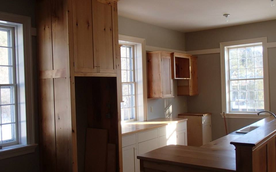 Wide pine planks salvaged from the closets of a historic in became rich, warm cabinetry for the upstairs living space.