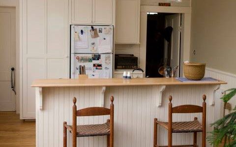 This simple white kitchen provides storage space in a former schoolhouse converted to a residence.