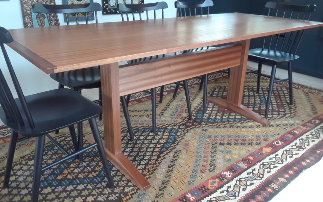 Clear finished dining room trestle table in sapele mahogany.